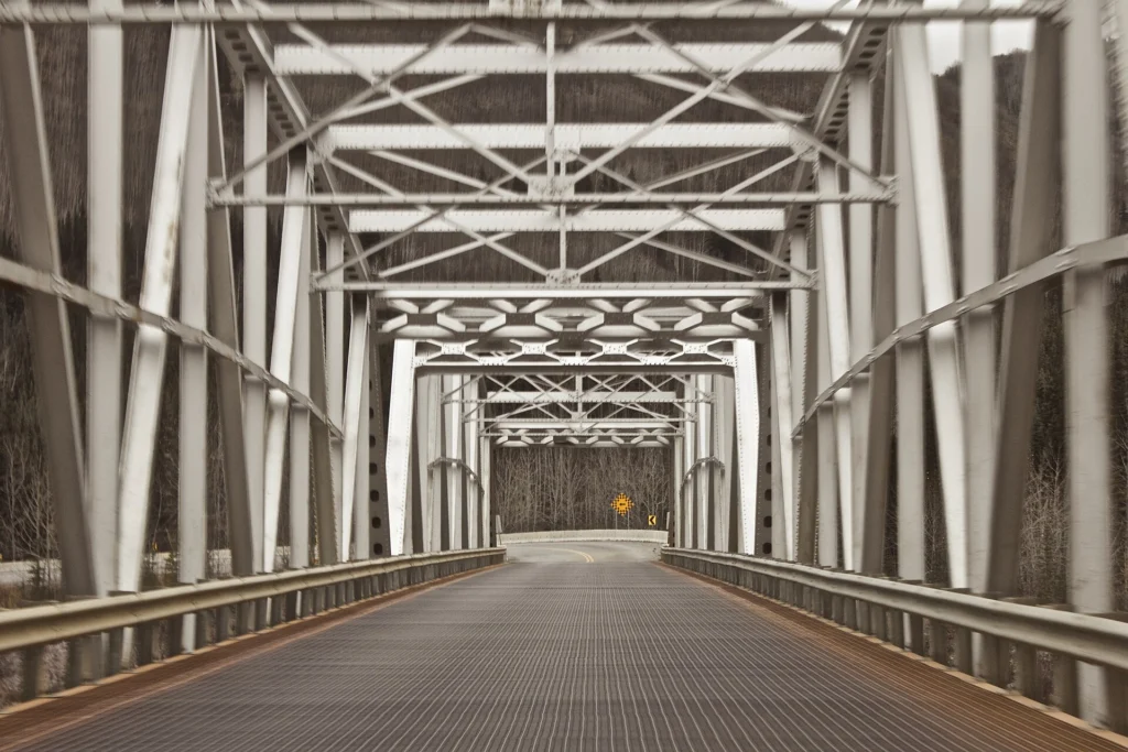 Steel truss bridge with a grated roadway and metal beams