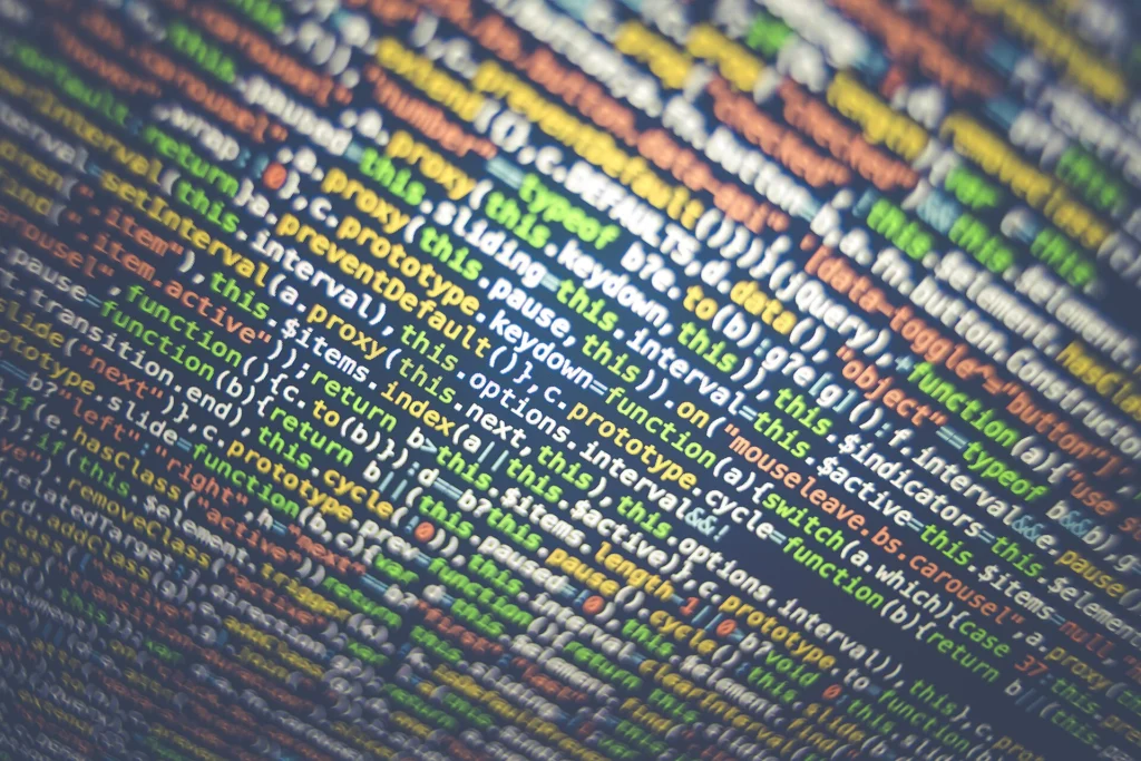 Dense lines of colorful JavaScript code filling a monitor screen