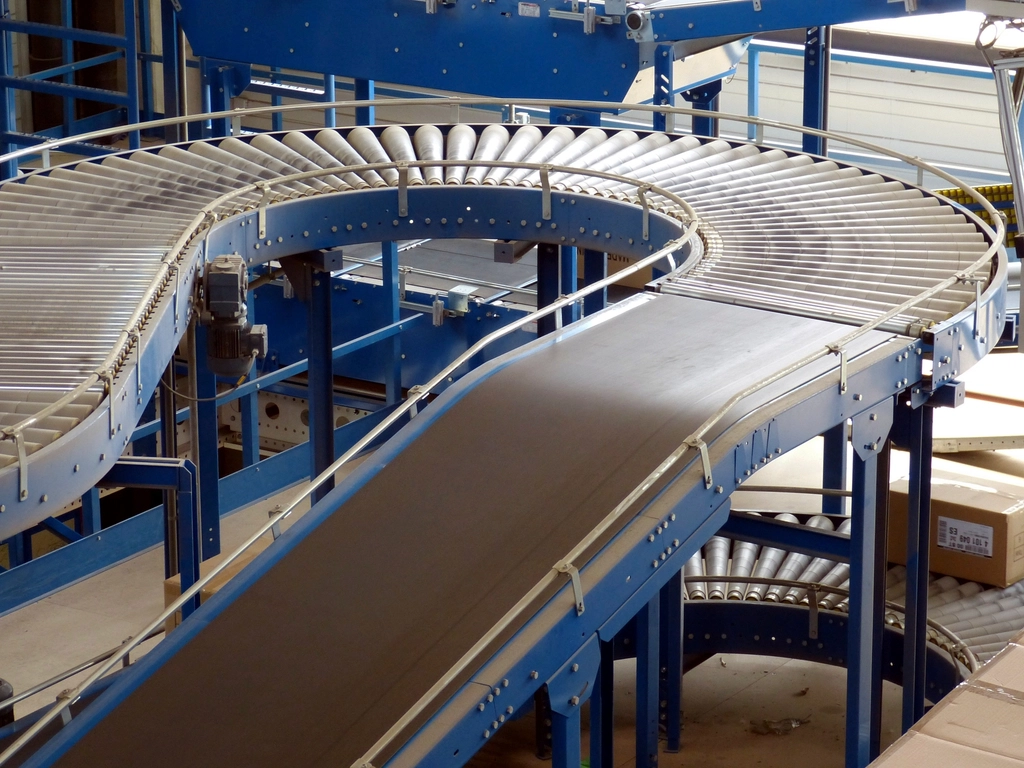 Process: Curved roller conveyor system in a modern logistics facility