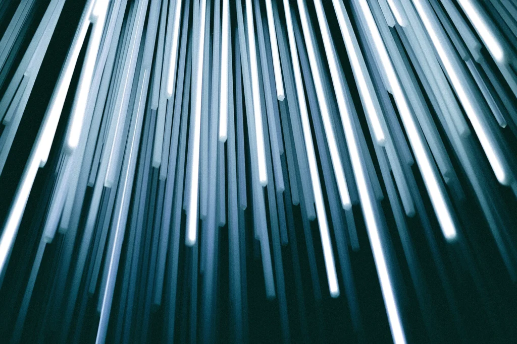 Migration: Glowing strands of fiber optic light against a dark background