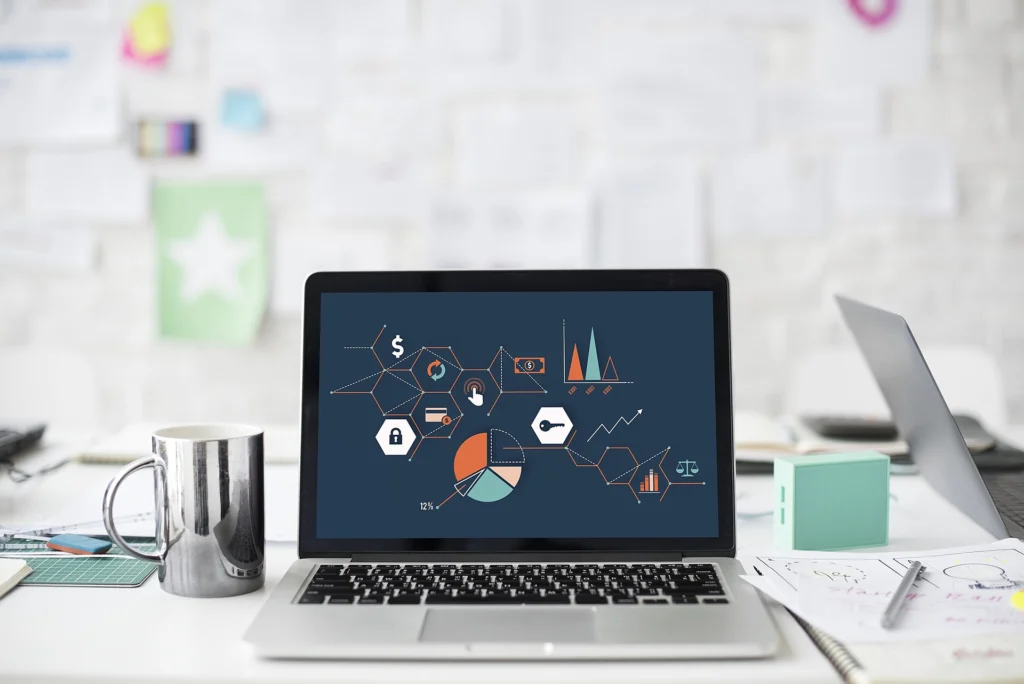 Laptop on a desk displaying several analytics charts and graphs