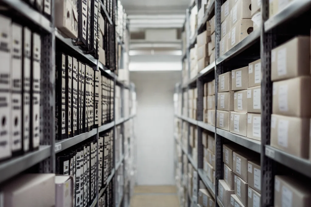 Long aisle of archive shelves stacked with labeled document boxes