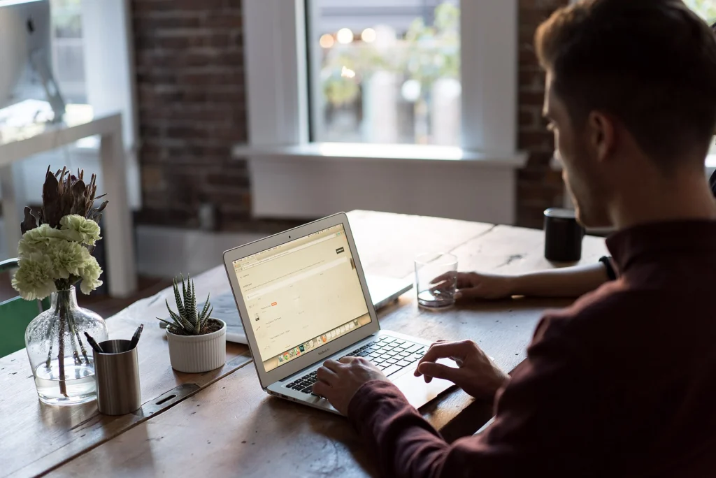 Chatbot: Support specialist working on a laptop at a wooden office table