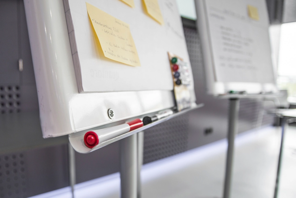Driven Design: Whiteboards with yellow sticky notes and markers in a workshop room