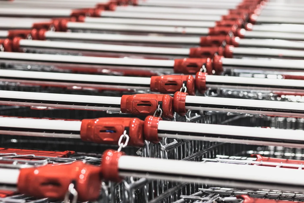 Long row of nested shopping carts with red handles in close-up