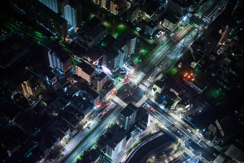 Edge: Aerial night view of a city intersection lit by street and traffic lights