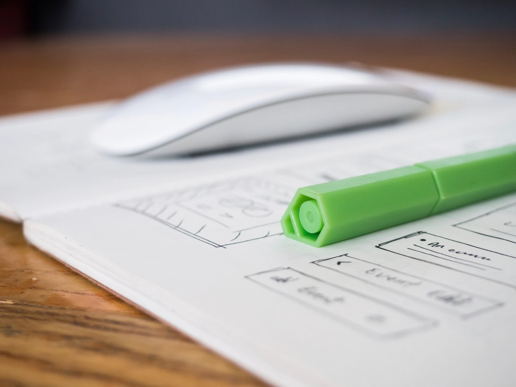 Hand-drawn app wireframe sketches with a green pen and a mouse