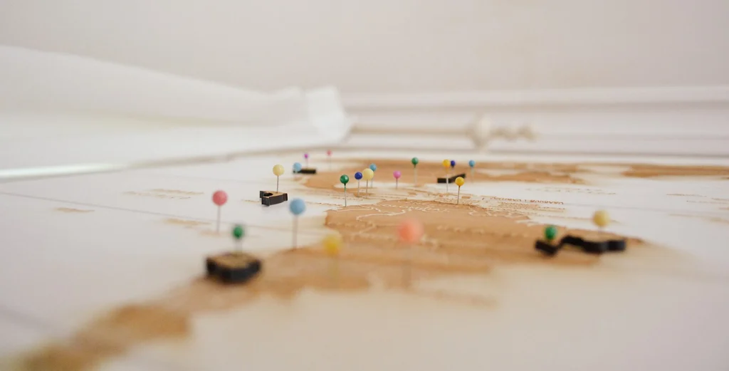 Light-coloured world map with colourful pins marking locations in different countries