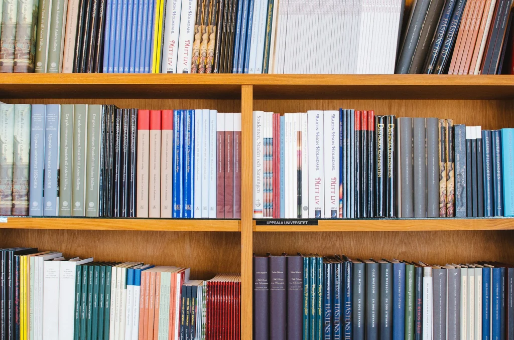 GraphQL: Neatly organized wooden library shelves filled with books by category