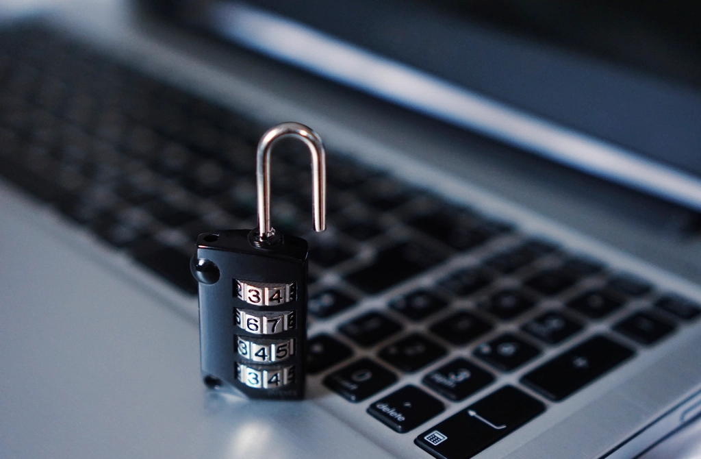 Open combination padlock resting on a laptop keyboard