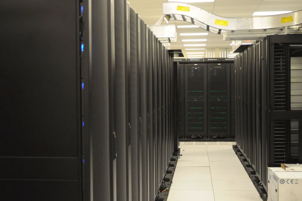 Long aisle of black server racks in a bright modern data center