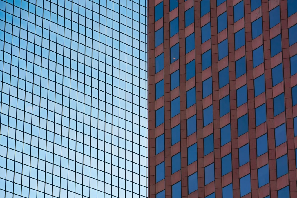 Two office towers with repeating grids of identical glass windows