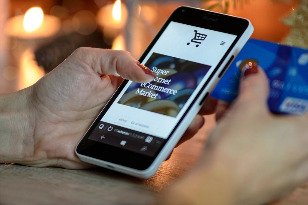 Gateway: Hands holding a smartphone with an online shop open and a payment card
