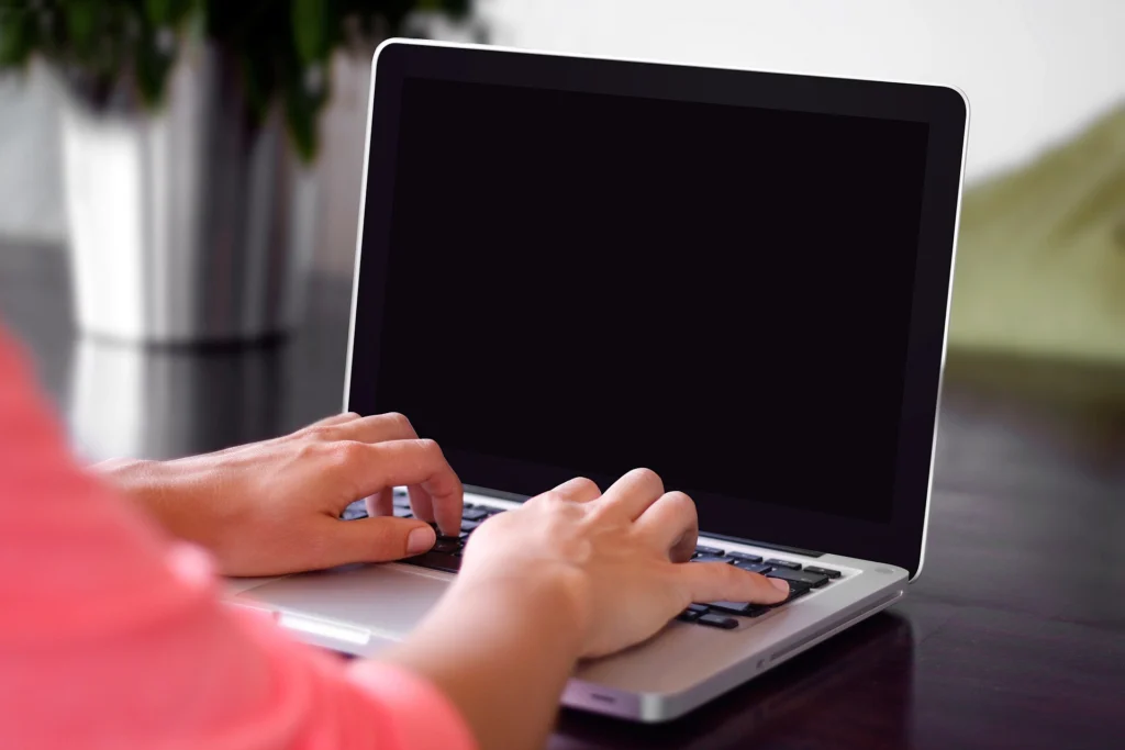 Authentication: Hands typing on a laptop keyboard while signing in to an application