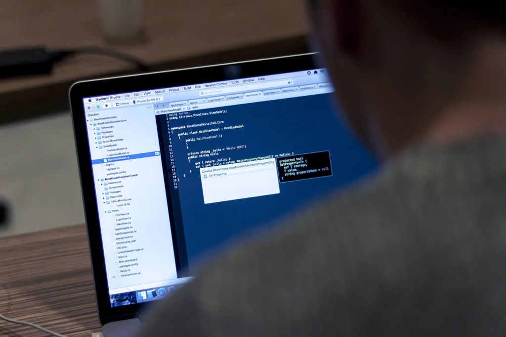 Developer looking at plugin source code in an IDE on a laptop
