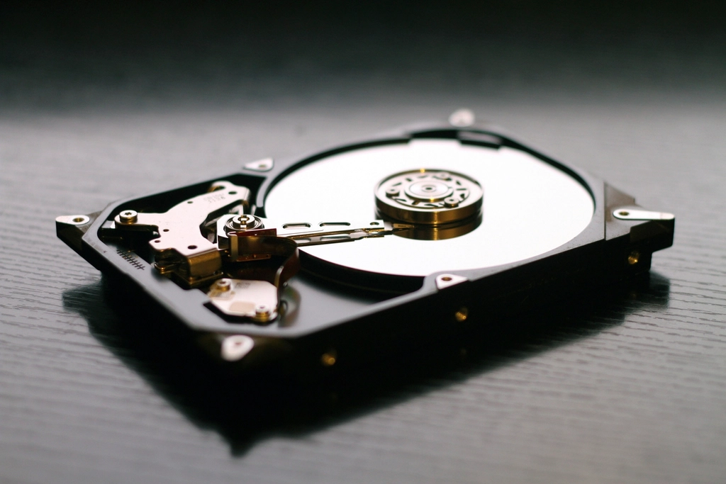 Open hard drive with a silver platter on a dark desk