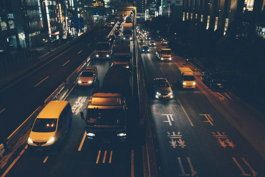 Cars moving in orderly lanes through a busy city road at night