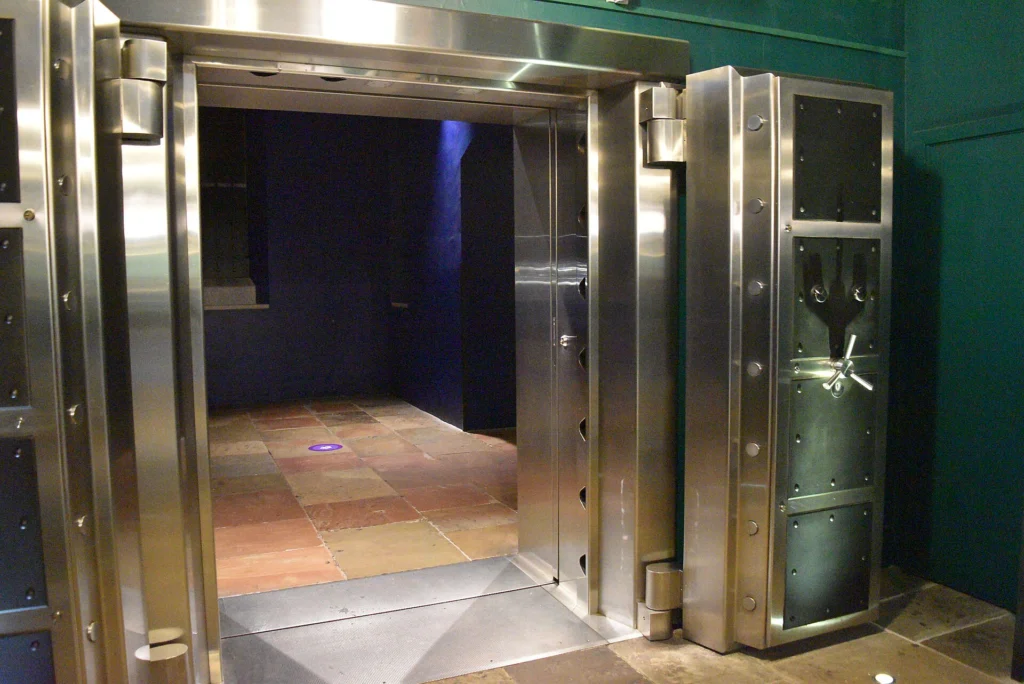 Open stainless steel vault door at the entrance of a secure room