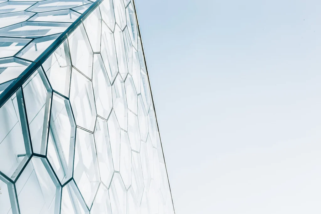Microservices: Glass building facade made of separate honeycomb-shaped cells against a pale sky