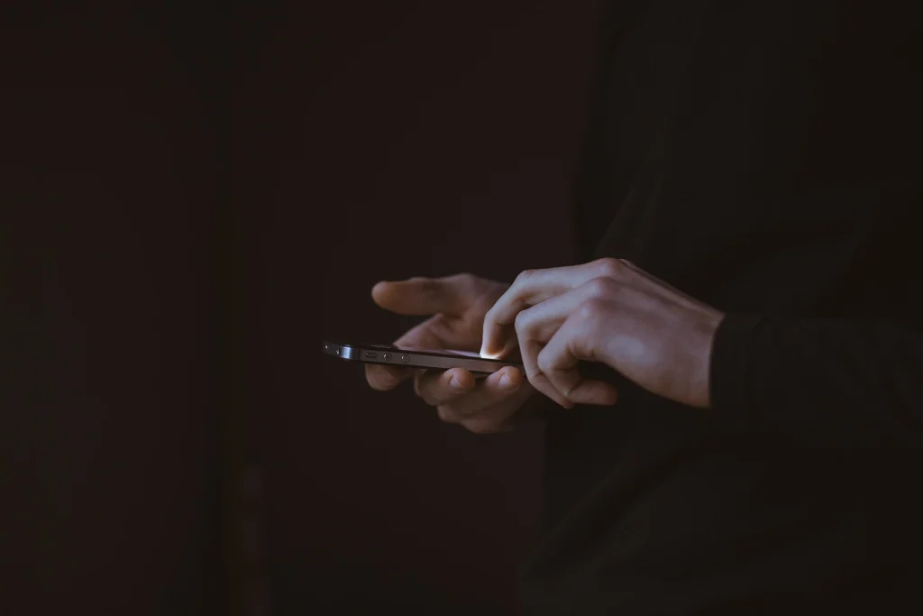 Hands holding a smartphone during agent actions on a website