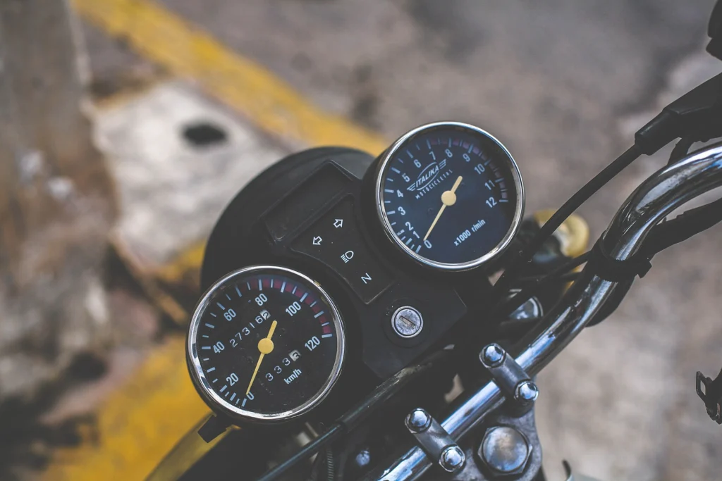 Speedometer and tachometer gauges on motorcycle handlebars seen from above