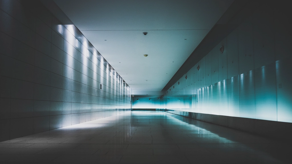 Long empty corridor with a small sensor on the ceiling